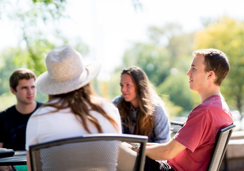 Students having a small group discussion outdoors