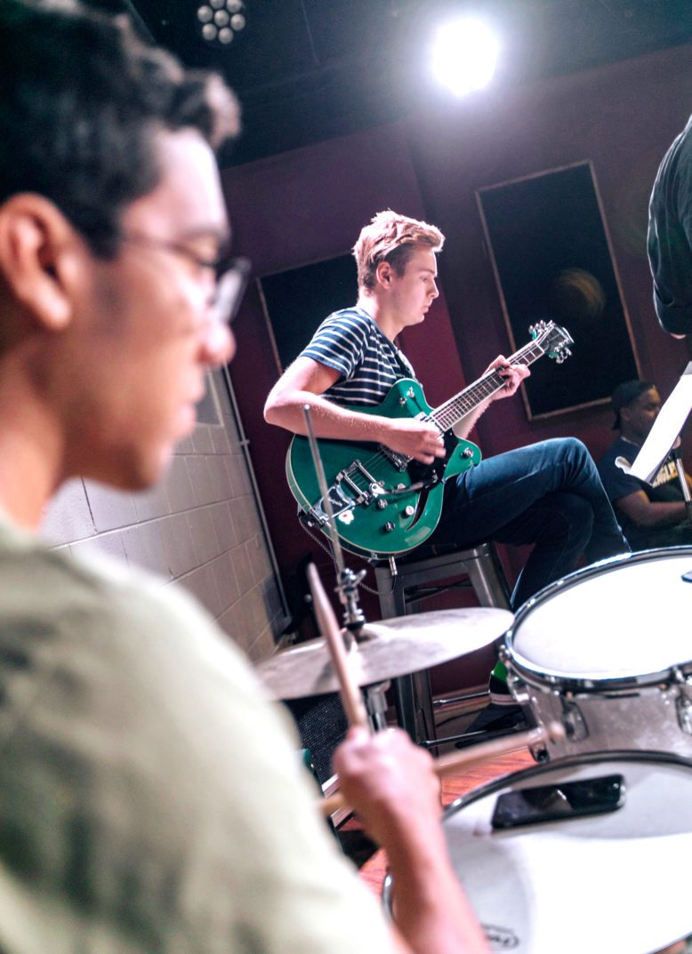 Music student drummer and guitarist performing