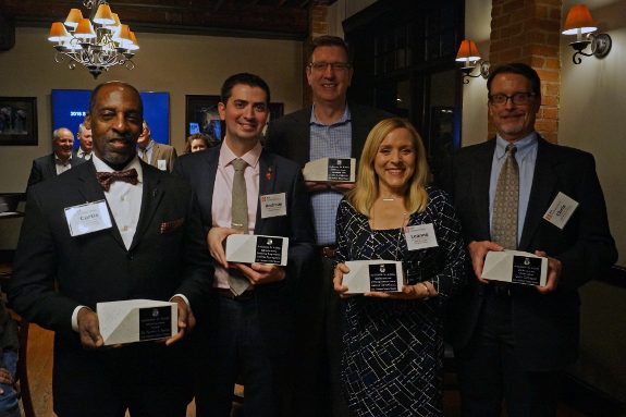 Dr. Sartor stands with an award amongst four other individuals at a ceremony