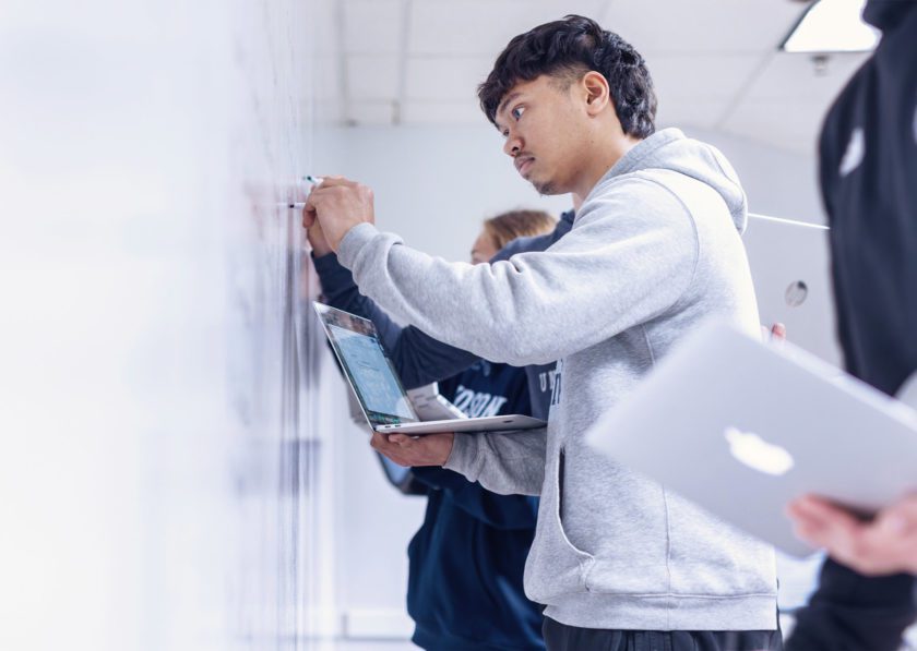 Student taking notes on a whiteboard