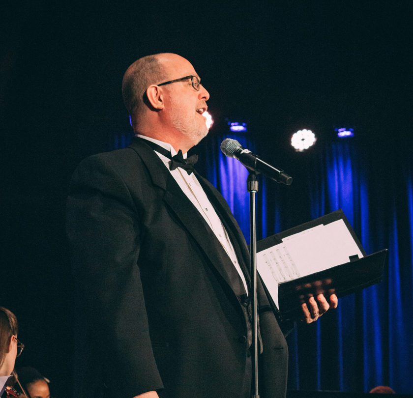 Dr. Anderson singing at a DCWPA performance