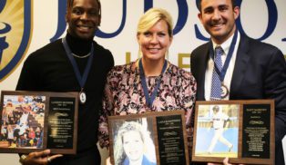 Two men and one woman holding awards